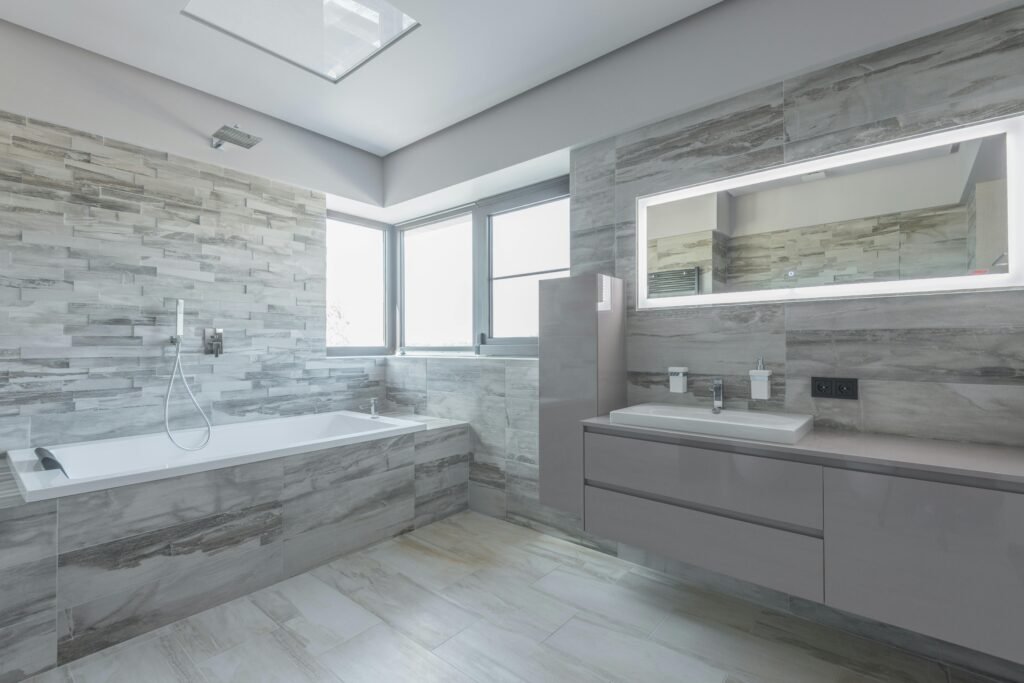 Sleek and spacious bathroom featuring a bathtub and reflective mirror.